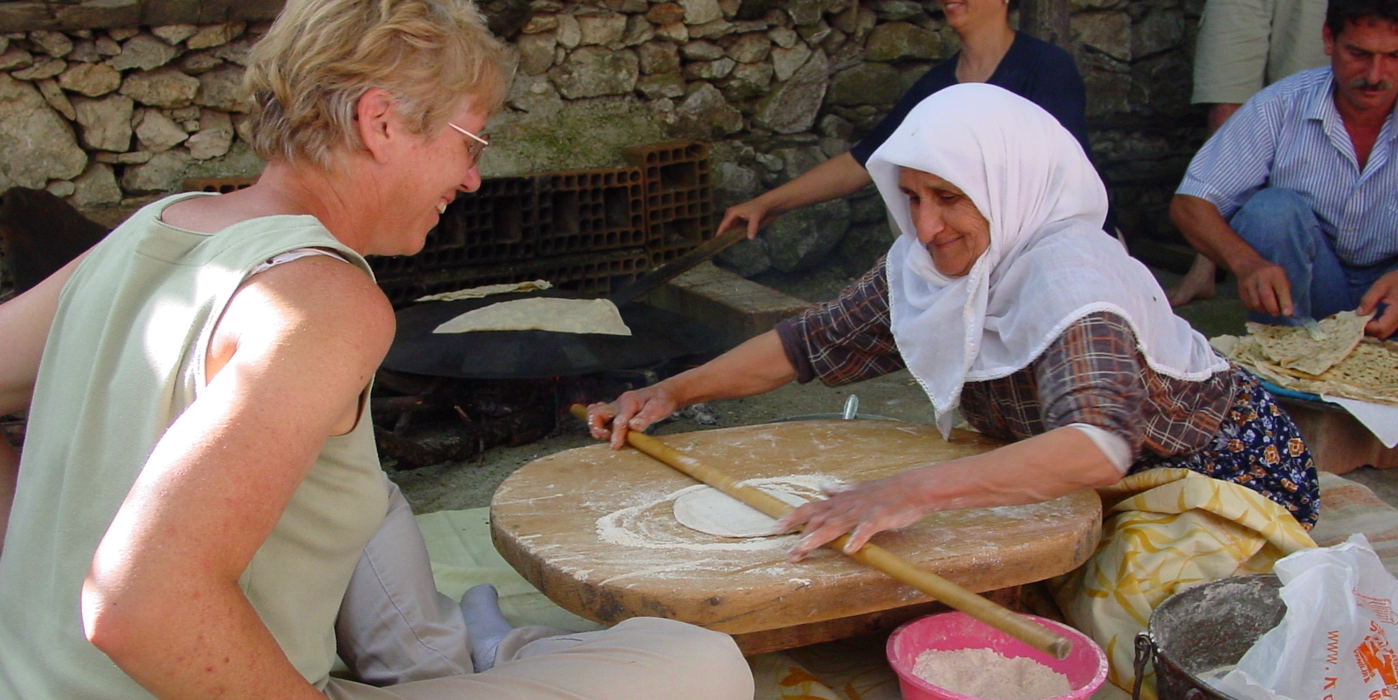 Turkish woman teaching an American woman how to make a traditional turkish meal