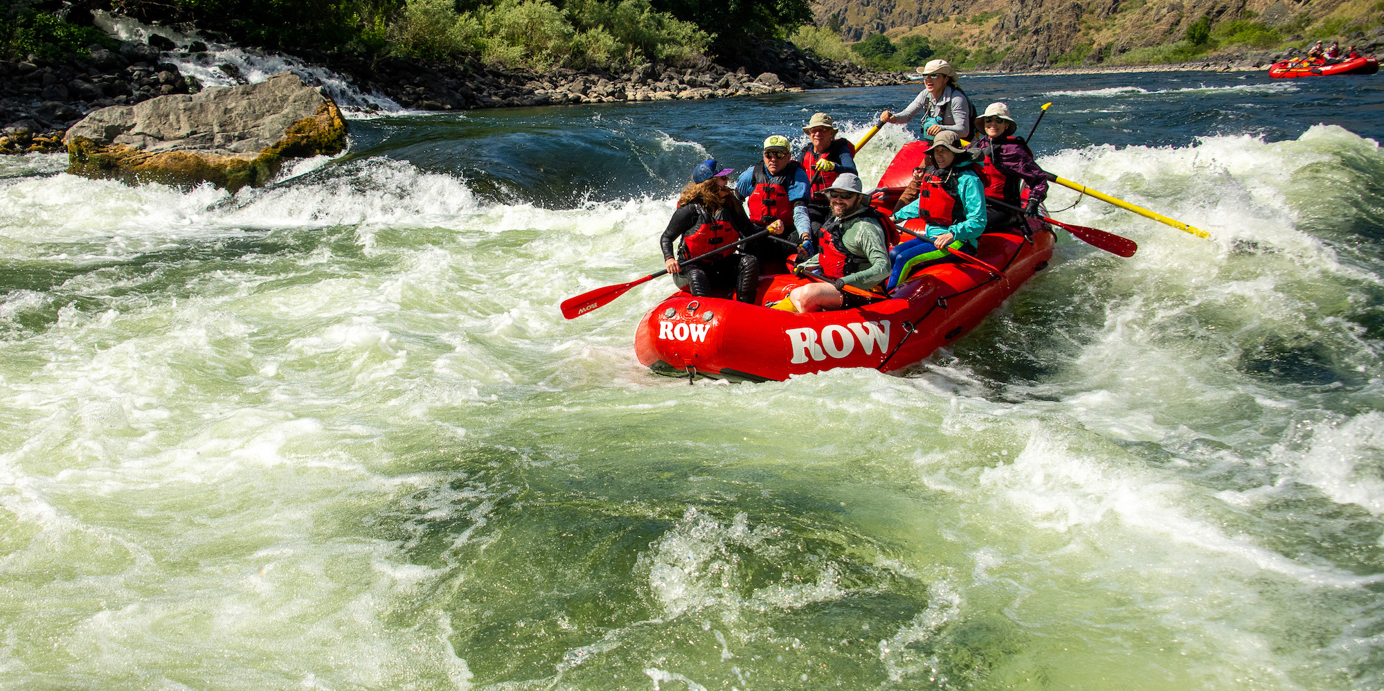 Upstream shot of a group rafting through a rapid on the Snake River through Hells Canyon
