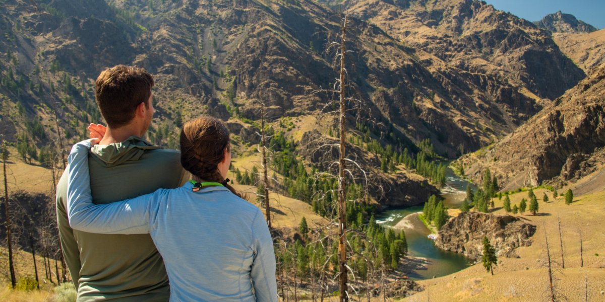 A couple overlooks the Salmon River from a vantage point along a riverside hiking trail