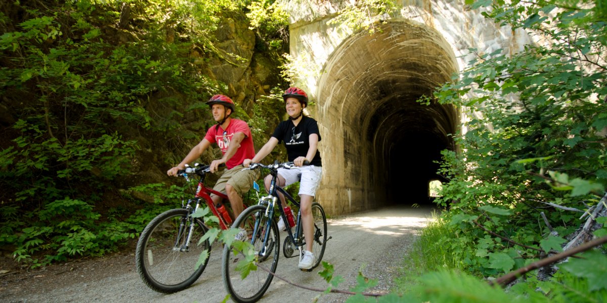 Guests ride through an old railway tunnel along the Hiawatha Trail in North Idaho