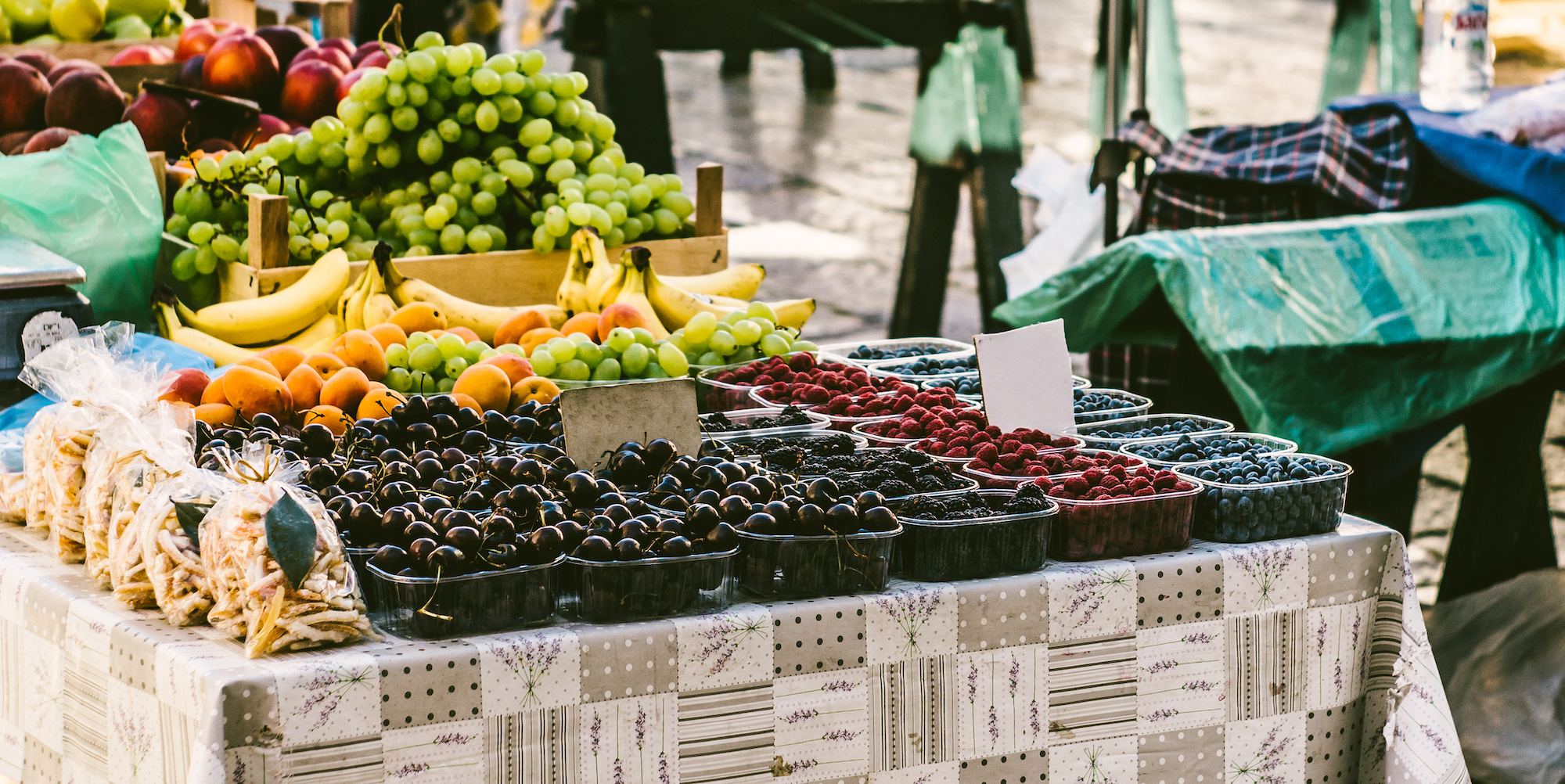 A variety of berries and other fresh fruit laid out on a table for a farmers market
