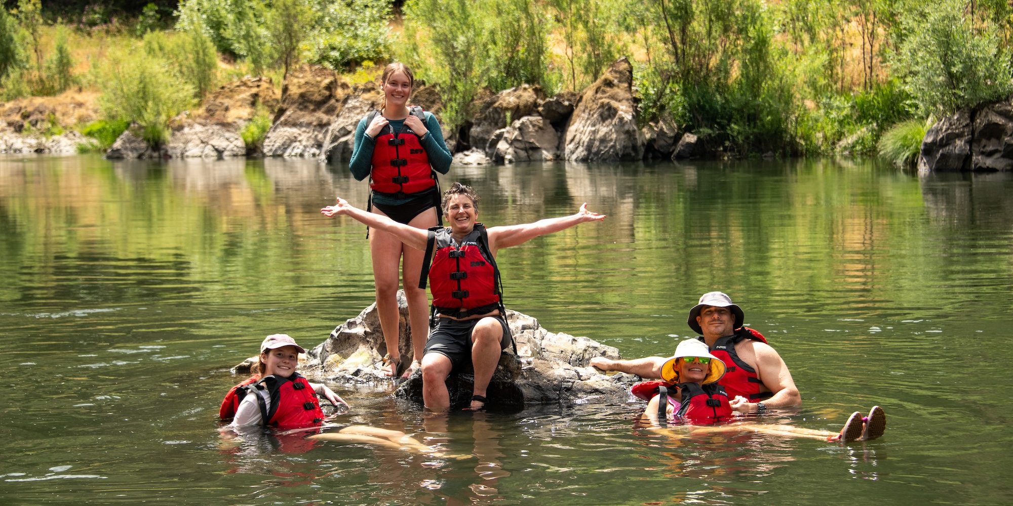 Group of rafters relaxing in calm water on a guided Pacific Northwest rafting trip, highlighting the fun and accessibility of short river vacations.
