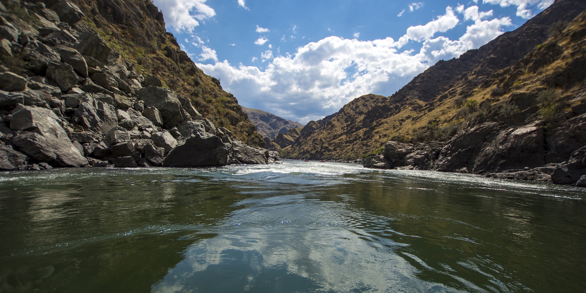 A tranquil stretch of river winds through a dramatic rocky canyon under a wide, open sky—offering a natural reset far from the noise of everyday life.